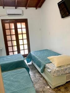 2 Betten in einem Zimmer mit Fenster in der Unterkunft Hotel Colonial Suites ,Bracel, Lwart, Zilor in Lençóis Paulista