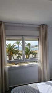 a bedroom with a window with a view of the beach at Moraira Beach 1 in Moraira