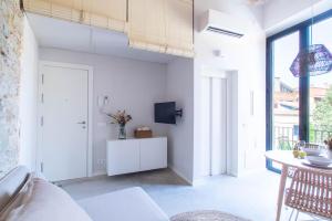 Domina Boutique Apartment في جيرونا: غرفة معيشة بيضاء مع أريكة بيضاء وطاولة