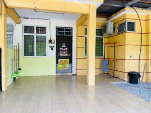a yellow and white building with a door at Niks Homestay Kok Lanas in Kampong Kok Lanas