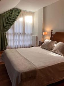 a bedroom with a large white bed with a window at Duplex 122m2, 4 dormitorios, 2 baños completos, Wifi 1GB in Mundaka