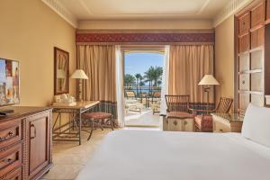 a hotel room with a bed and a living room at Mosaique Beach Resort Taba Heights in Taba