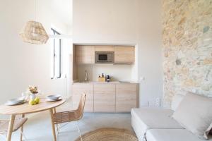 a kitchen and living room with a table and a couch at Domina Boutique Apartment in Girona
