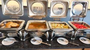 a buffet with trays of food on a table at StayBird - AERITH STUDIOS, Exclusive Residences, Kharadi in Pune