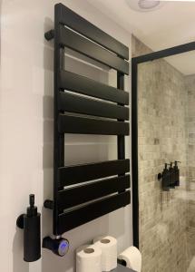 a bathroom with a black towel rack above a toilet at Cosy Central Hideaway in St. Leonards