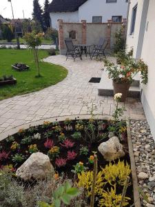 Weberhof في Egenhofen: حديقة فيها ورد وصخور على الفناء