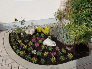 a garden with flowers and rocks in a circle at Weberhof in Egenhofen