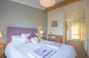 ein Schlafzimmer mit einem weißen Bett und Handtüchern darauf in der Unterkunft Luxury family Beechwood lodge with hot tub in Lochwinnoch