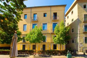 un gran edificio con una sombrilla delante de él en Domina Boutique Apartment, en Girona