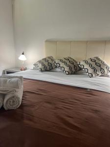 Un dormitorio con una cama con almohadas. en Departamento Porá en Puerto Iguazú