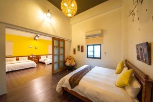 een slaapkamer met een groot bed en een gele muur bij 宜蘭種子民宿 in Yuanshan