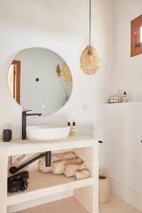 bagno con lavandino bianco e specchio di Finca las Calmas boutique hotel & retreats a Moraleda de Zafayona