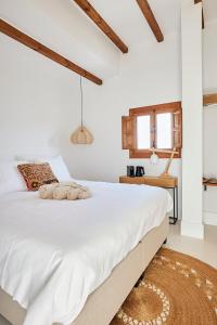 um quarto com uma cama grande e lençóis brancos em Finca las Calmas boutique hotel & retreats em Moraleda de Zafayona