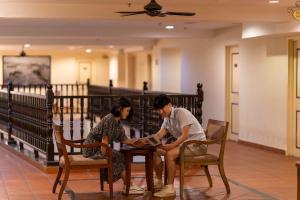 un uomo e una donna seduti a un tavolo di Armenian Street Heritage Hotel a George Town