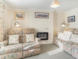 a living room with a couch and a fire place at Rose Cottage in Pembrey