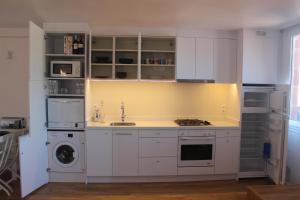 a kitchen with white cabinets and a washer and dryer at Apartamento Walden in San Justo Desvern