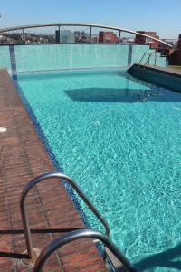 una piscina de agua azul y una terraza de madera en Apartamento Walden, en Sant Just Desvern