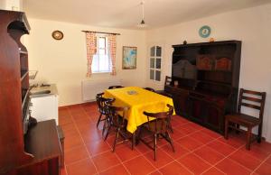 a kitchen with a table with a yellow table cloth at Kis-Balatoni Ökoporta in Zalaszabar