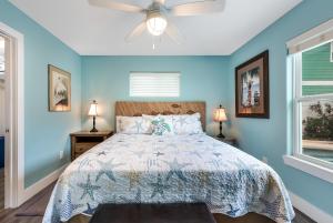 een blauwe slaapkamer met een bed en een plafondventilator bij Diving Dolphin in Port Aransas