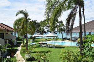 a resort with a swimming pool and palm trees at Kasagpan in Tagbilaran City