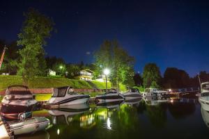 a group of boats docked in the water at night at Hotel Robert's Port in Mikołajki