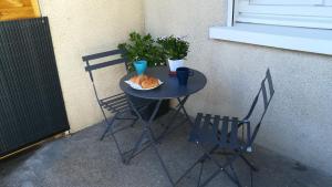 a small table with chairs and a plate of food on it at Besançon appartement T2 sur cour intérieure proximité gare in Besançon +6 photos