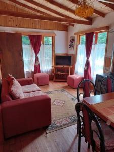 sala de estar con sofá rojo y mesa en Cabaña del Volcán, en Licán Ray