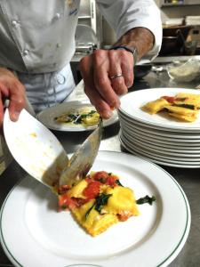 a chef cutting a piece of pizza on a plate at Hotel Al Verde in Mandello del Lario