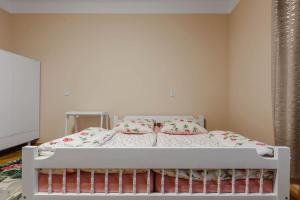 een slaapkamer met een wit bed met roze kussens bij Apartament Astronomiczne miejsce in Przemyśl