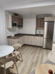 a kitchen with stainless steel appliances and a table and chairs at Apartamentos Doña Emilia in Adeje