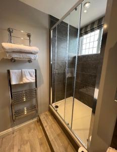 uma casa de banho com um chuveiro e uma cabina de duche em vidro. em The Dog Inn em Longridge