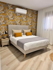 a bedroom with a large bed with yellow pillows at Apartamentos Doña Emilia in Adeje
