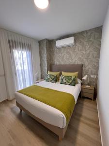 een slaapkamer met een groot bed en een groene deken bij Apartamentos Doña Emilia in Adeje