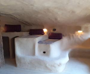 a room with two beds in a cave at Maison Terre Les Cabanes de Fallot in LʼIsle-Bouzon