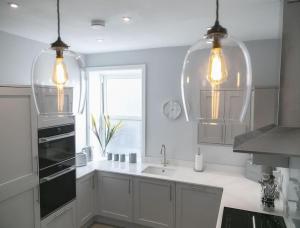 a white kitchen with a sink and a window at 45a Oxford Street in Harrogate