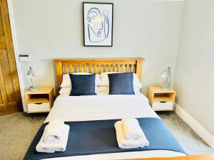 um quarto com uma cama grande e almofadas azuis em Horsforth Lodge em Horsforth