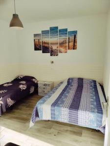 Costa del Silencio El Drago في طوستا ديل سيلونثيو: غرفة نوم بسريرين ولوحتين على الحائط
