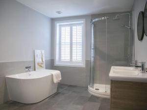 a bathroom with a tub and a shower and a sink at 45a Oxford Street in Harrogate