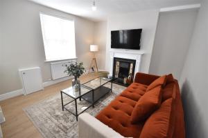 a living room with a couch and a fireplace at 2 bedroom house in Hoylake - Golf Open in Hoylake