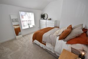 een slaapkamer met een bed, een dressoir en een spiegel bij 2 bedroom house in Hoylake - Golf Open in Hoylake