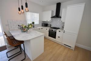een keuken met witte kasten en een aanrecht bij 2 bedroom house in Hoylake - Golf Open in Hoylake