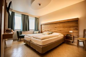 a hotel room with a large bed and a desk at Logis Hotel La Métairie & Son Auberge in Trois-Ponts