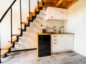 a kitchen with white cabinets and a staircase at Domki SHERWOOD 