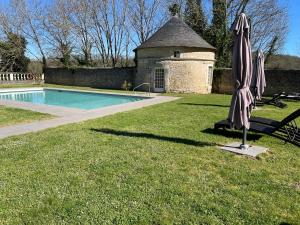 um guarda-chuva sentado na relva ao lado de uma piscina em Hapimag Château de Chabenet em Chabenet