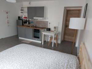 1 dormitorio con 1 cama y cocina con mesa en Studio tout confort, en Corny-sur-Moselle