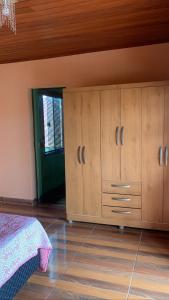a bedroom with a bed and wooden cabinets at Jeitinho da Sô in Tiradentes +10 photos
