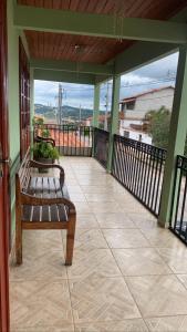 a porch with a bench sitting on a balcony at Jeitinho da Sô in Tiradentes