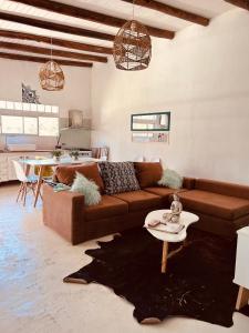 sala de estar con sofá marrón y mesa en Mirador del Río en Villa La Rivera