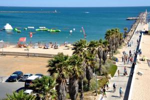 una playa con palmeras y gente en la playa en Praia da Rocha - 1Bdr - 2 Pools - Beach at 300m, en Portimão