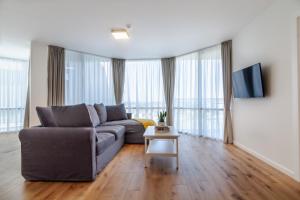 a living room with a couch and a table at Elija Swan-Toy Apartments in Šventoji